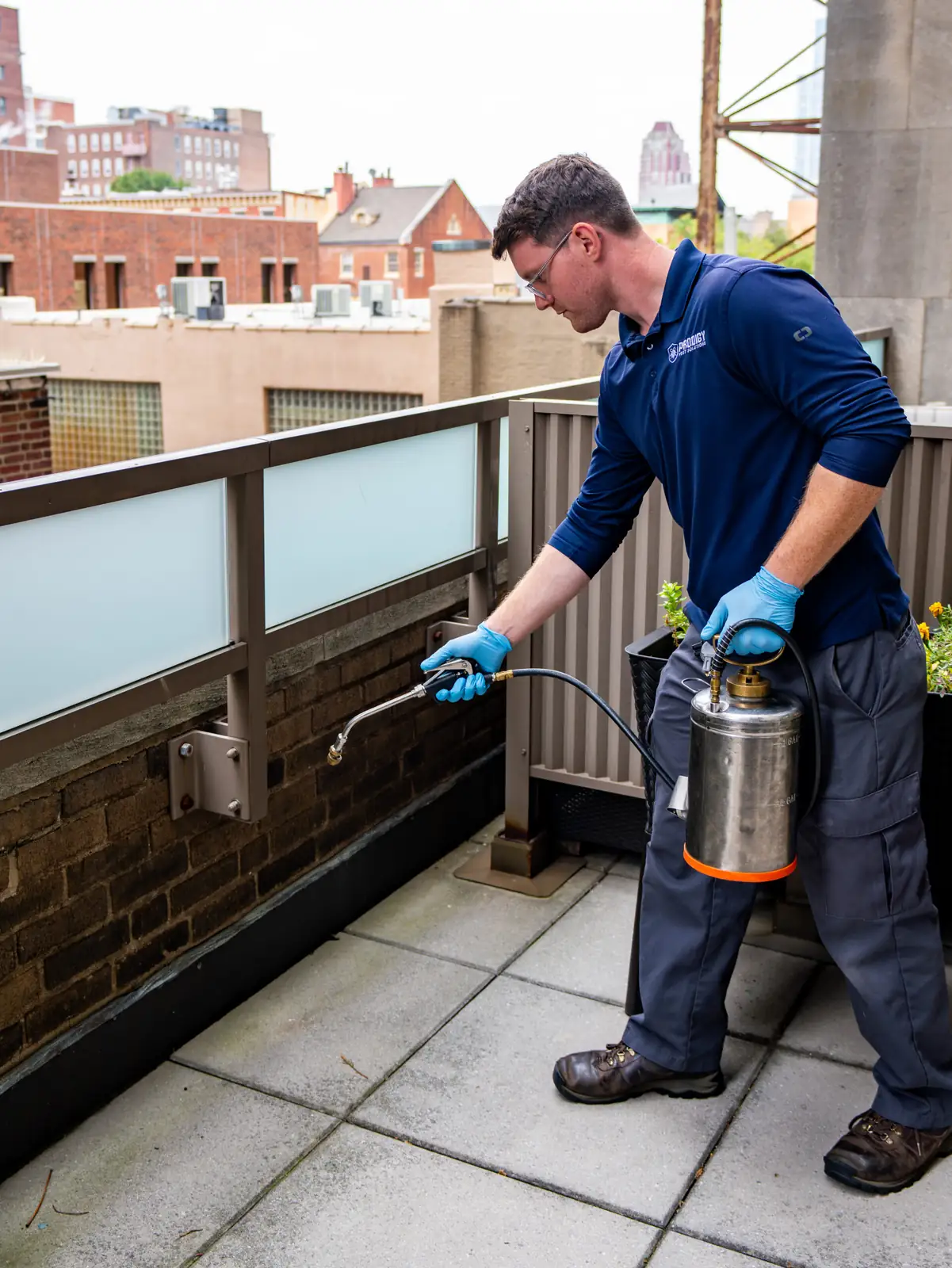 Prodigy Pest Solutions technician treating the exterior of a Philadelphia home