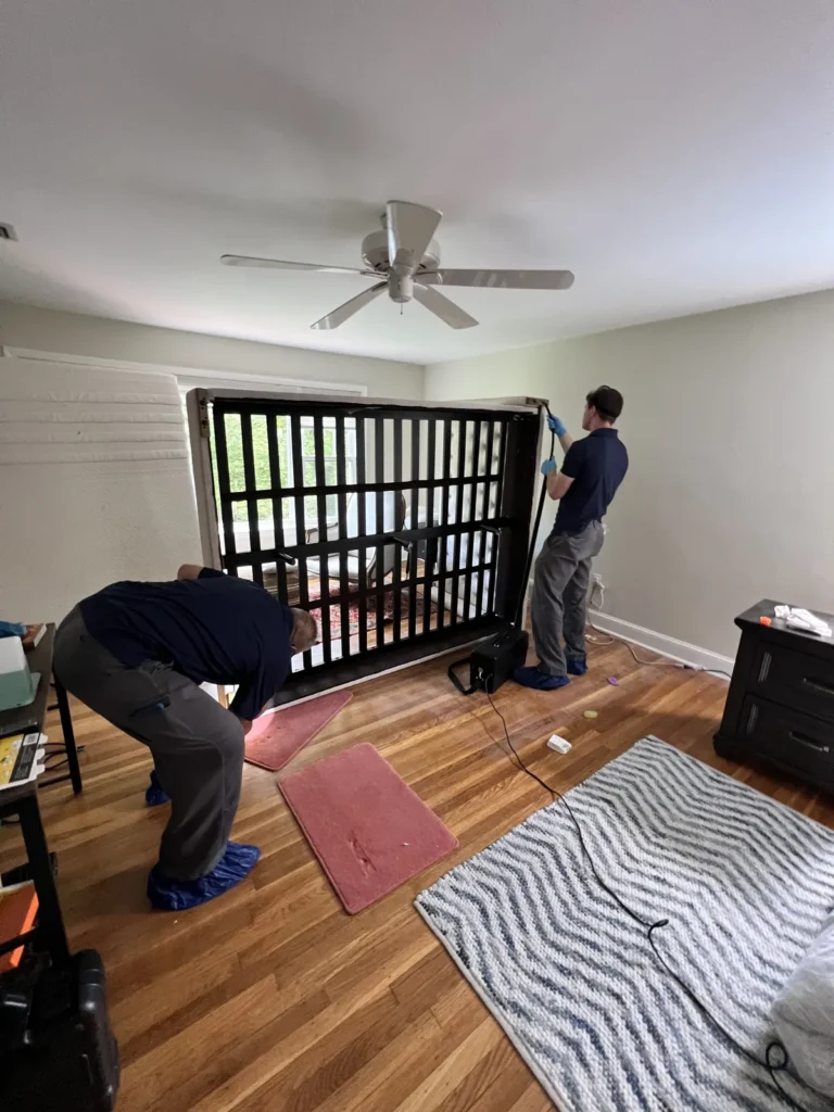 Prodigy technicians applying Aprehend bed bug treatment to a bed frame in a Delaware County home